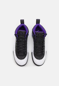 Paire de baskets montantes noires et blanches avec une doublure intérieure violette et des lacets noirs, vues de dessus sur fond blanc.
