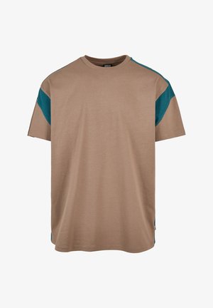 Beige bomull T-skjorte med avslappet passform, korte ermer og kontrasterende turkise detaljer langs skuldrene. Ingen merkbare mønstre eller hardware.