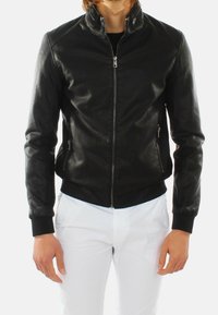 Giubbotto bomber in pelle nera con zip frontale, colletto rialzato e tasche laterali. I polsini e l'orlo a coste migliorano il design aderente.