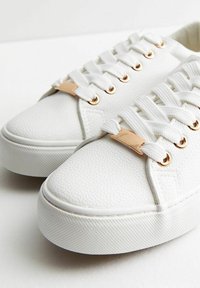 Vita lädersneakers med en texturerad finish, försedda med guldtonade detaljer vid snörhålen och en rund tå. Platta vita snören fulländar designen.
