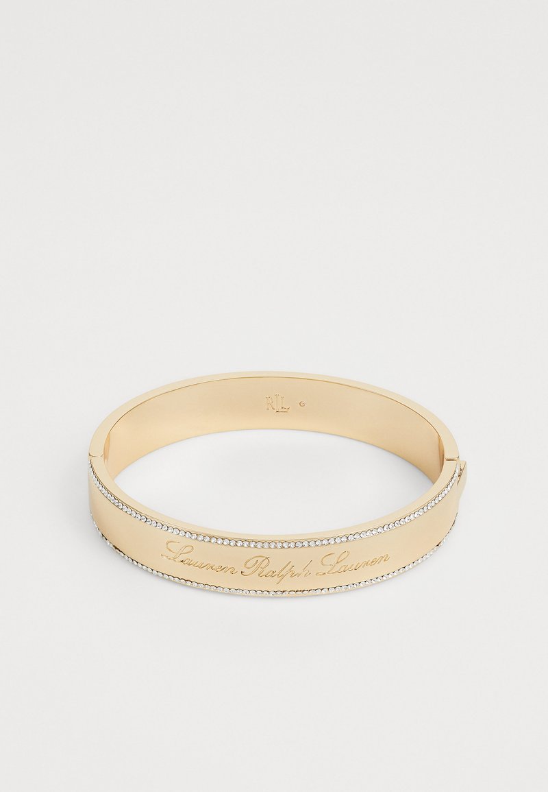Goldener Armreif mit eingraviertem "Lauren Ralph Lauren"-Text und einer Reihe kleiner klarer Steine entlang der Kante. Glatte Oberfläche, elegantes Design.