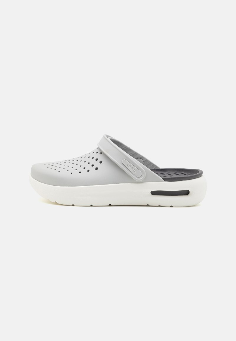Gray clog with a textured upper featuring cut-out holes, a back strap, and white sole accents. Smooth finish and ergonomic shape.