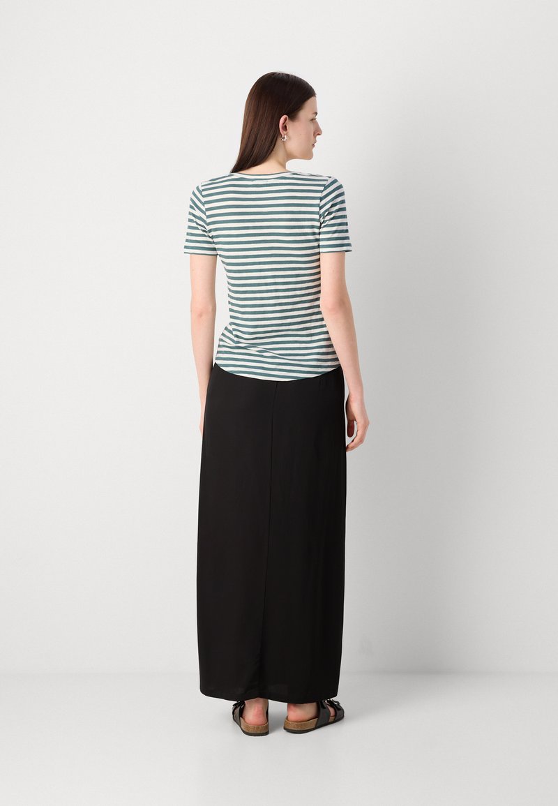 Strefowany, krótki top w kolorze turkusowym i białym, zestawiony z czarną spódnicą maxi. Top ma okrągły dekolt i dopasowany krój.