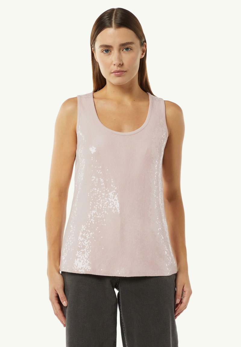 Rosa ärmelloses Oberteil mit einem Rundhalsausschnitt, bedeckt mit Pailletten für Textur und Glanz, kombiniert mit dunkelgrauten Hosen.