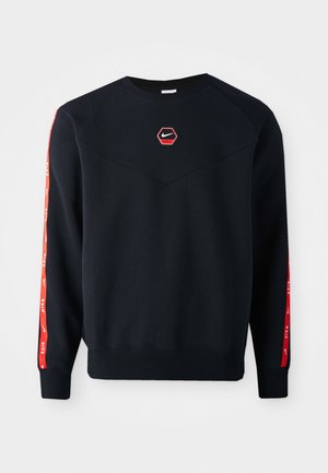 Sweatshirt marine avec un logo Nike rouge hexagonal sur la poitrine. Présente des accents rouges le long des manches et un tissu texturé et doux.