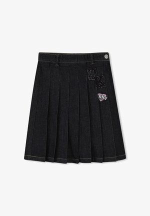 Jupe en jean noire plissée avec passants pour ceinture et écussons de la marque DKNY sur la partie supérieure avant droite.