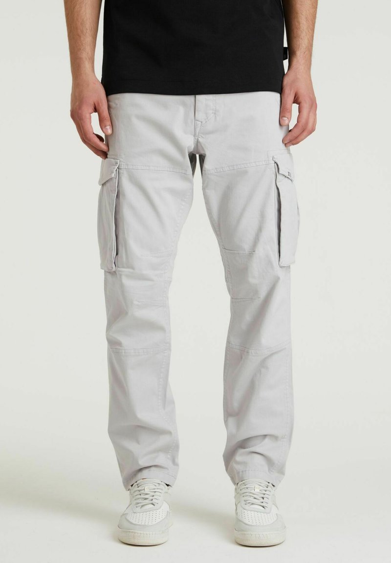 Lys grå cargo bukser lavet af en bomuldsblanding, med flere sidelommer, lige pasform og lynlåselementer. Båret med hvide sneakers.