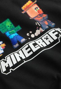 Tela negra con temática de Minecraft que presenta personajes pixelados: un zombi verde, un personaje con sombrero y un pato blanco, con el texto en blanco "MINECRAFT" en negrita.