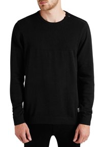 Czarny sweter z prążkowaną fakturą na górnej części, okrągłym dekoltem, długimi rękawami i kontrastową gładką dolną częścią.