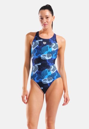 Blå mønstret badedragt med en blanding af mørke og lyse blå nuancer. Har høj hals og brede stropper, lavet af et glat materiale.