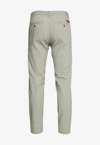 Pantalon en lin vert clair à jambes droites, avec deux poches arrière et des accents de boutons marrons, texture douce et design uni.