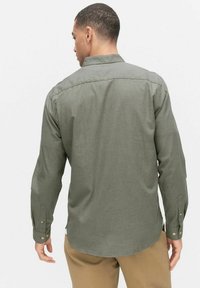 Heren overhemd met lange mouwen in olijfgroen, gemaakt van een gestructureerde stof. Voorzien van een button-down kraag en knopen op de mouwen, met een afgeronde zoom.