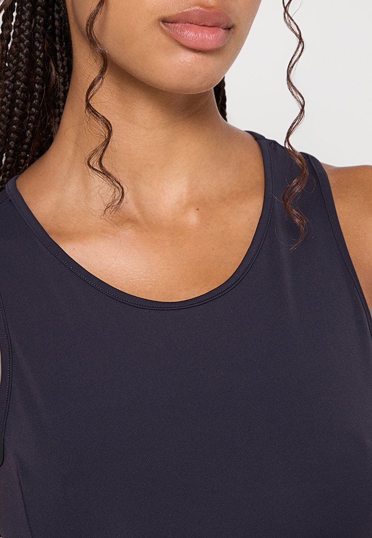 Canottiera sportiva blu scuro con scollatura tonda, texture liscia e vestibilità comoda, con treccia su una spalla.