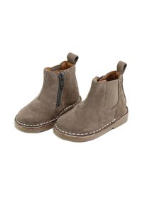 Botines de ante marrón con cremallera lateral, paneles elásticos y costuras blancas alrededor de la suela. Punta redondeada y presillas en cada lado.