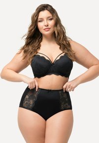 Zwart lingerieset met een gebreide kant bh met gekartelde randen en een hoge taille slip met kanten zijkanten en een strikdetail.