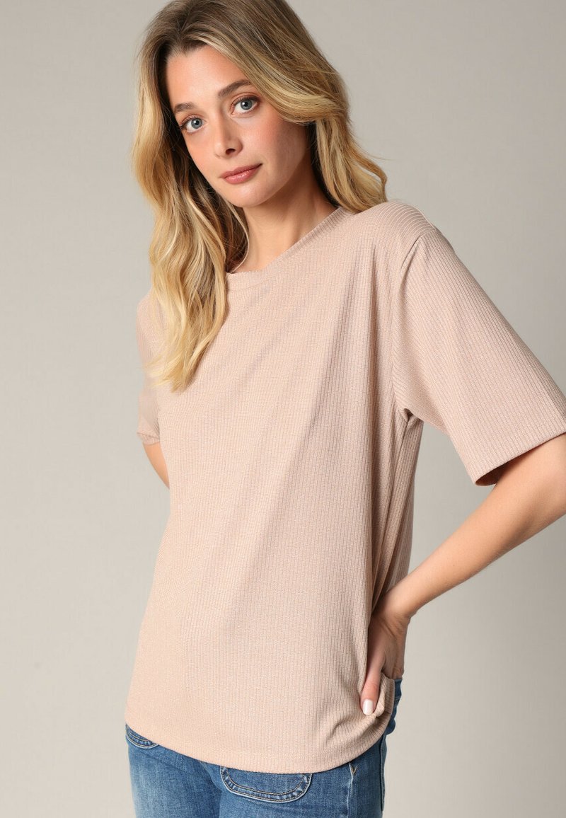 T-shirt à rayures beige clair avec des manches courtes et une coupe décontractée. Le tissu a une texture douce et présente un col en V subtil.