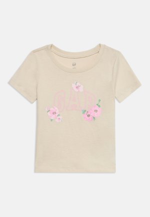 Μπεζ κοντομάνικο παιδικό μπλουζάκι με ροζ λογότυπο GAP και floral σχέδιο μπροστά, στρογγυλή λαιμόκοψη, βαμβακερό ύφασμα.