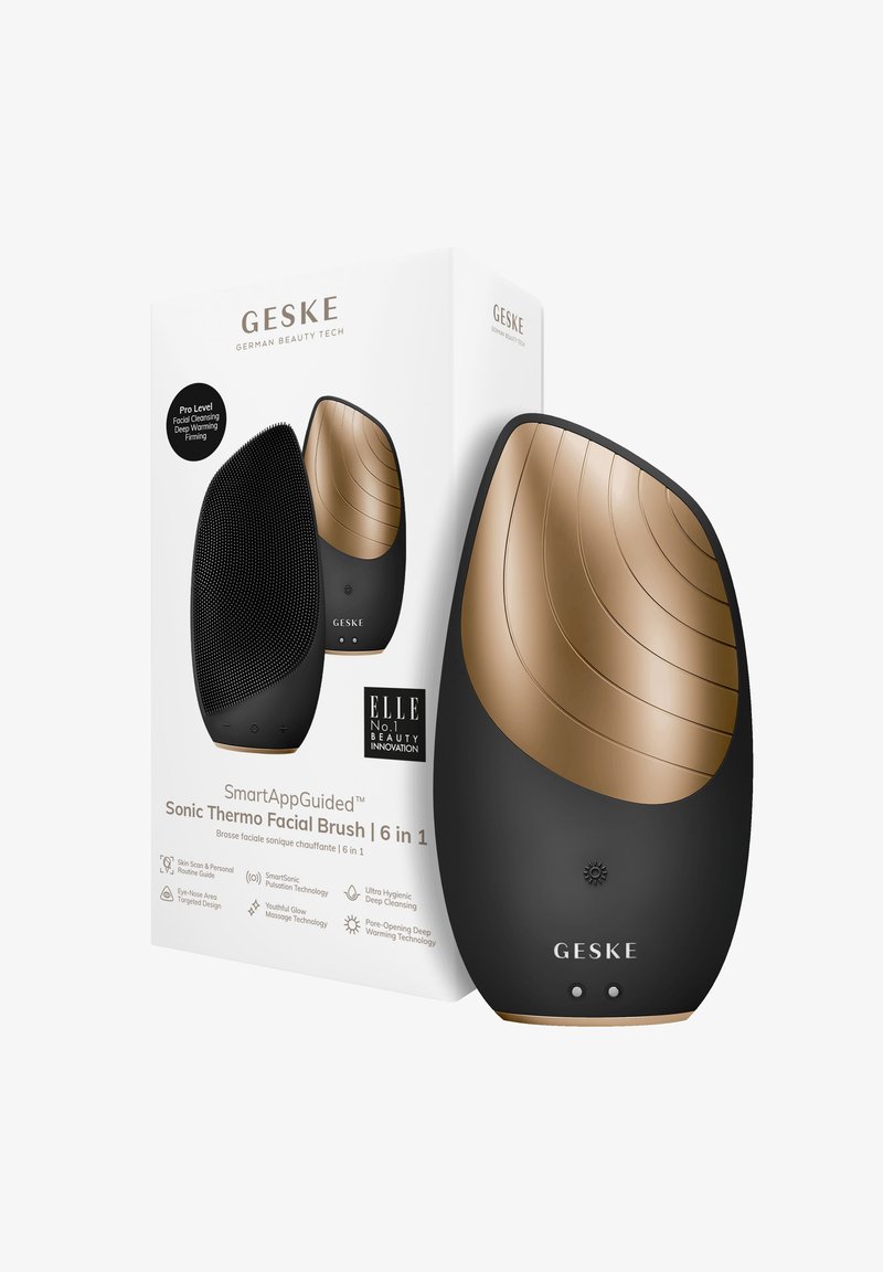 De Sonic Thermo Facial Brush in zwart en goud beschikt over een gestructureerd siliconen oppervlak, een ergonomische vorm en een strak design, verpakt in een witte doos.