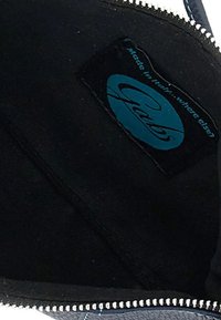 Fodera in tessuto nero con un'etichetta blu del marchio Gabs visibile all'interno di una tasca con zip, il testo recita "Fatto in Italia... dove altro?"
