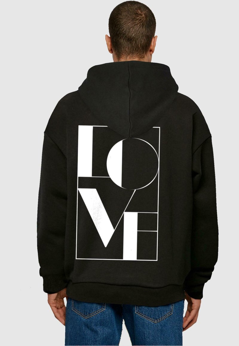 Čierna mikina s kapucňou vyrobená z fleecového materiálu, s veľkým bielym grafickým nápisom "LOVE" na chrbte, doplnená geometrickými prvkami a kapucňou.