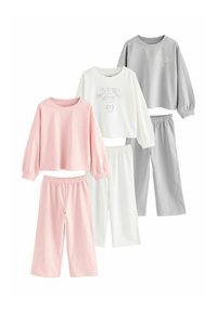 Trzy zestawy loungewear w pastelowych kolorach z długim rękawem i szerokimi spodniami w kolorach różowym, białym i jasnoszarym.