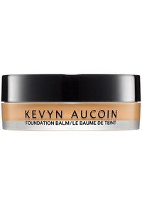 Kevyn Aucoin Foundation Balm in a round container, with a black lid and beige product, features minimal text in bold black font.