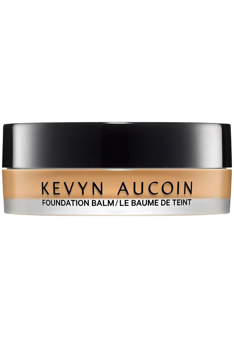 Kevyn Aucoin Foundation Balm in a round container, with a black lid and beige product, features minimal text in bold black font.