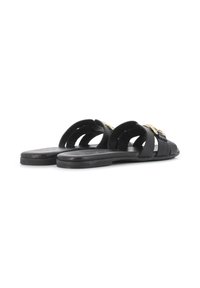 Sandalias planas negras con un diseño trenzado, que presentan una textura suave y detalles en hardware dorado. La suela es plana y flexible.