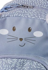 Blauer Stoffrucksack mit einem stilisierten Tiergesicht, das Knopfaugen, Schnurrhaare und ein strukturierte Muster aufweist. Mit einem Reißverschlussverschluss.