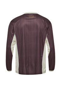 Langærmet sportstrøje med lodrette hvide tynde striber på mørk bordeauxstof og hvide sidepaneler, der viser bagud.