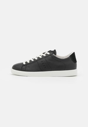Sorte lædersneakers med hvide snørebånd, en tekstureret hæl og minimalistisk design. Har perforerede sideaccenter og en hvid gummisål.