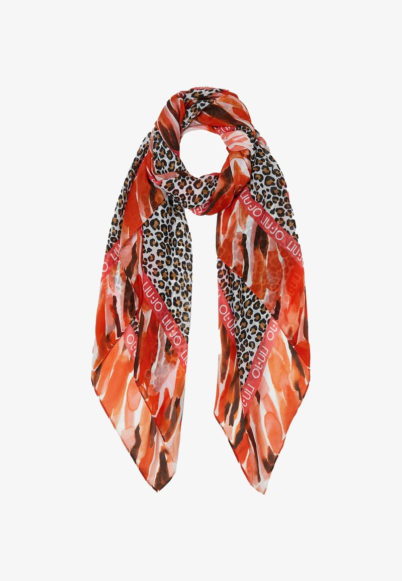 Écharpe en soie présentant un motif vibrant orange et brun avec des accents à motif léopard et une marque rouge, affichant un design léger et texturé.