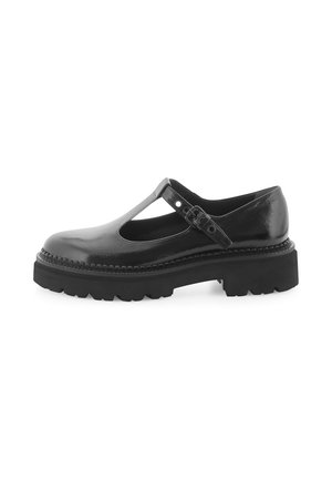 Chaussure T-bar en cuir noir, avec un bout rond, sangle à boucle ajustable, semelle en caoutchouc épaisse avec une texture striée, et détails cousus.