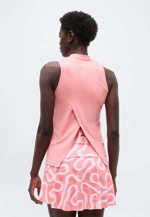 Γυναίκα, που φαίνεται από πίσω, φοράει ένα ροζ αμάνικο τοπ με σκίσιμο στο πίσω μέρος και μια ροζ φούστα με παρόμοιο σχέδιο.