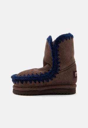Brun ruskind ankle boot med mørkeblå uldtrim, flad sål og rundet tå, designet til varme og afslappet brug.