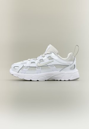 Λευκό και ανοιχτό γκρι αθλητικό παπούτσι με διχτυωτά και συνθετικά εξωτερικά στρώματα, χοντρή σόλα και θηλιά στη φτέρνα, στραμμένο αριστερά σε ουδέτερο φόντο.