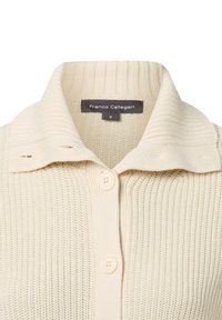 Crème-kleurige gebreide cardigan met een gestructureerd ribpatroon, voorzien van een opstaande kraag en twee knopen. Tag leest "Franco Callegari," maat S.