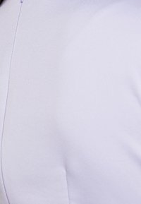 Lila tyg, slät textur, skräddarsydd design, har en sömdetalj längs kanten. Närbild av materialet utan synlig hårdvara.