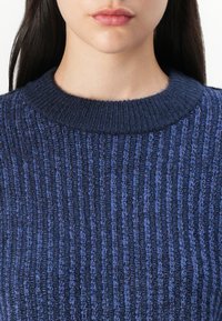 Maglione a maglia blu scuro con costine verticali, scollatura rotonda e una finitura texturizzata con diverse sfumature di filati blu.