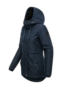 Navy blue jacket with a faux fur-lined hood, drawstring closure, and snap button accents. Features two front pockets and ribbed cuffs.