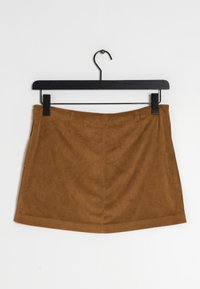 Hnědá semišová mini sukně s hladkou texturou, pasem a vertikálními švy. Visí na černém kovovém ramínku na bílém pozadí.