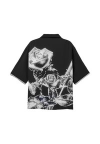 Chemise noire à manches courtes avec des motifs de roses pixelisées blanches couvrant le dos et des poignets de manche rayés blancs.