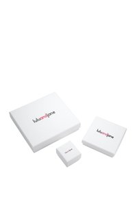 Cutii de ambalaj albe de dimensiuni variate, cu un design minimalist. Cea mai mare cutie are inscripția "luluandjane" în text negru și roz pe capac.