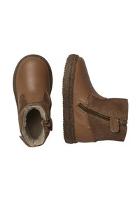 Botas de tobillo marrones con parte superior de cuero, detalles de ante, cierre de cremallera y suela de goma texturizada, con un forro suave visible en el interior.