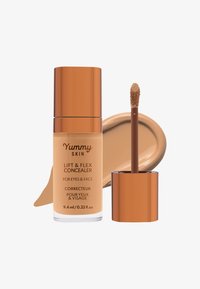 Yummy Skin Lift & Flex Concealer i en klar glassflaske med gulllokk, ledsaget av en brun applikatorstav og en kremfargeprøve.