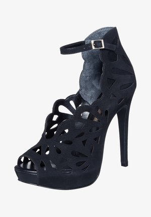 Chaussure noire à talons hauts avec un design floral découpé, bout ouvert, bride de cheville et texture lisse. Présente une silhouette élégante et une semelle plateforme.