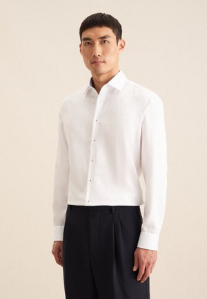 Weißes Langarmhemd mit Button-Down-Kragen und fünf vorderen Knöpfen. Es hat einen glatten Stoff und eine taillierte Passform und wird mit dunklen Hosen getragen.
