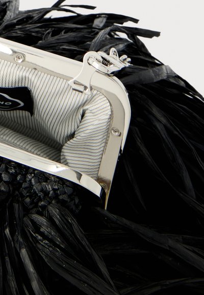 Sac à main noir tissé avec un cadre et un fermoir en métal argenté, doté d'une doublure en tissu rayé à l'intérieur du sac ouvert.