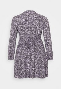 Vestido de manga longa em cinza escuro com estampa de flores roxas, apresentando uma cintura justa com detalhe de laço e uma saia rodada.