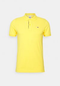 Polo shirt jaune en coton avec un col, une patte de boutonnage à trois boutons et un petit logo sur la poitrine gauche. Manches courtes.